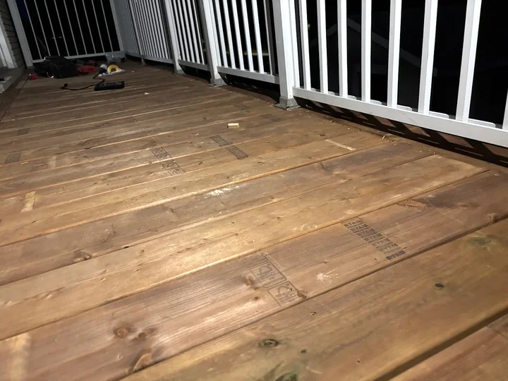 Wooden deck boards beside a white railing