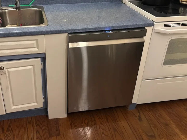 Stainless steel dishwasher fitted beneath a kitchen counter